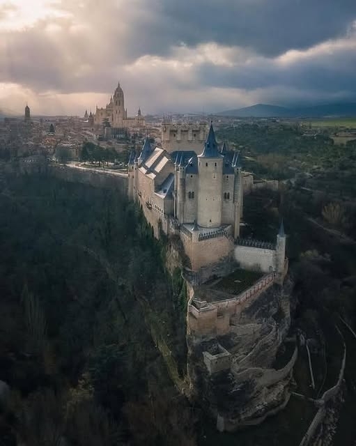 Der Alcázar de Segovia - ist Spaniens berühmteste Burg. Die Anlage auf dem Hügel war lange Zeit eine Festung. Zuerst hatten die Römer hier ein Militärlager. Es wurde durch ein hölzernes Fort aus der muslimischen Zeit ersetzt, das schließlich nach der Rückeroberung des Landes einer christlichen Festung wich. Doch es war König Johann II., der die alte und baufällige Festung in eine prächtige Burg umbaute, die wir heute alle bewundern, insbesondere den Turm von Johann II. Philipp II. fügte die spitzen Türme hinzu. In der frühen Neuzeit war die Burg ein Ort von äußerster zeremonieller Bedeutung: Isabella, die Monarchin, die das goldene Zeitalter Spaniens prägte, wurde hier Mitte des 15. Jahrhunderts gekrönt. Doch als der königliche Hof nach Madrid umzog, wurde die Burg in ein Gefängnis umgewandelt. Später beherbergte sie eine Artillerieschule. 1862 fing der Alcázar ein Feuer aus, das Dächer, Türme und obere Stockwerke fast aller Gebäude zerstörte. Zu diesem Zeitpunkt erfuhr die Welt von dem Juwel und restaurierte das Schloss im Einklang mit der damals angesagten übertriebenen romantischen Mode.